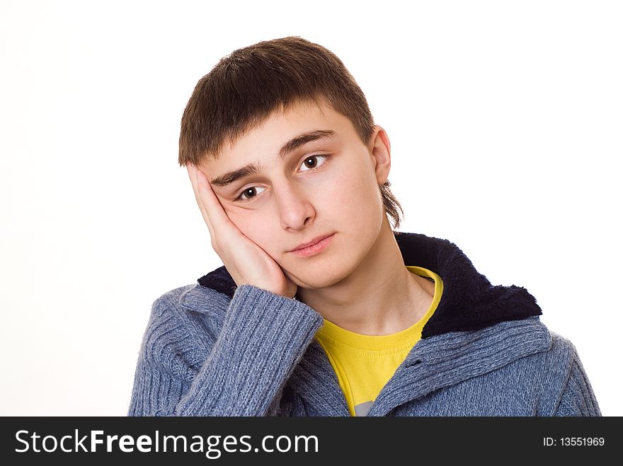 Handsome young teenager standing and thinking on a white background