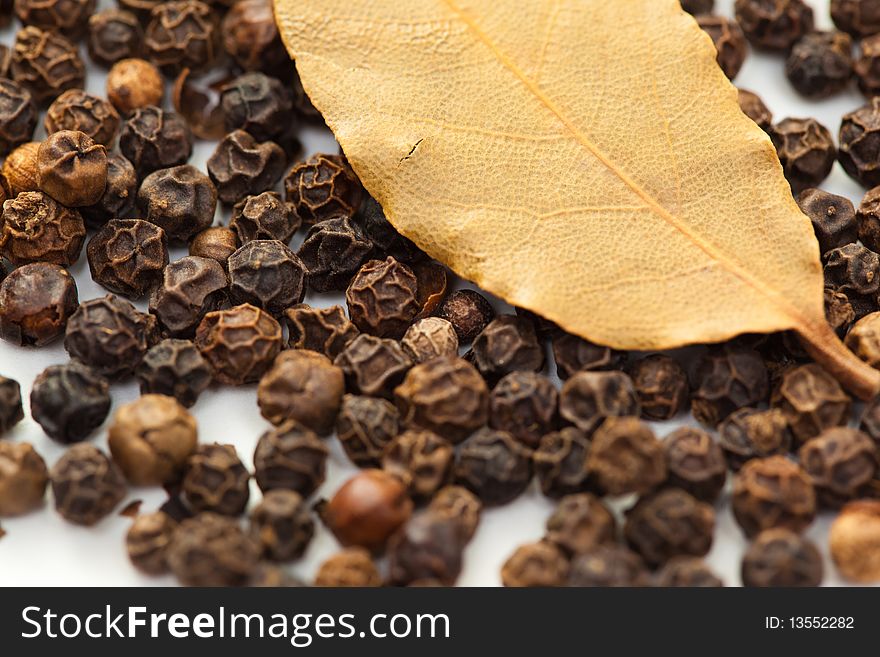 Pepper with dry bay leaf isolated on white.