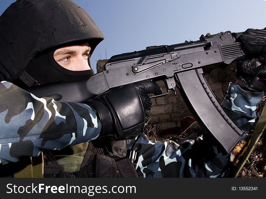 Soldier shooting with an AK47 automatic rifle from covered position. Soldier shooting with an AK47 automatic rifle from covered position