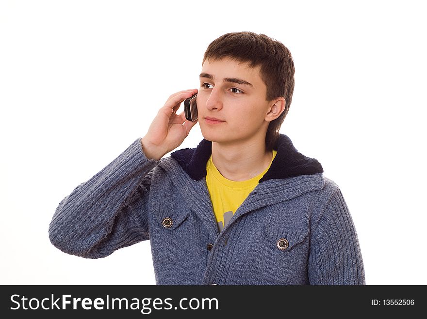 Beautiful teenager in a blue blouse talking on the phone on a white background