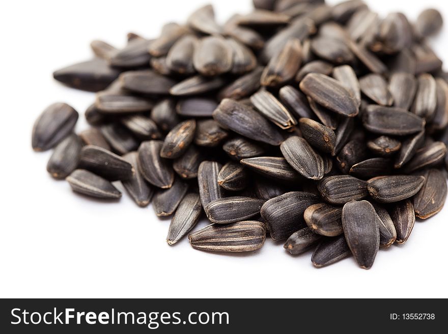 Pile of sunflower seeds against a white background
