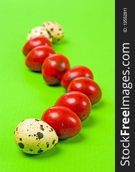 Red and white easter eggs on green background