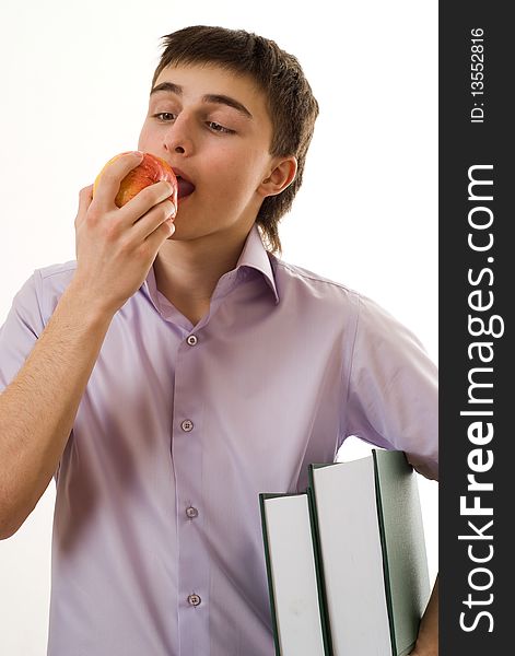 Handsome young student eats an apple on a white background
