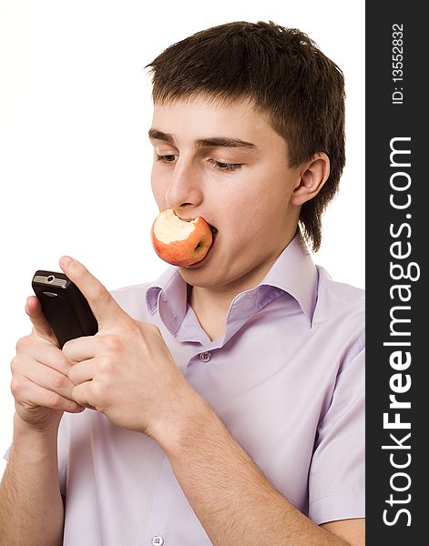 Handsome young student eats an apple on a white. Handsome young student eats an apple on a white