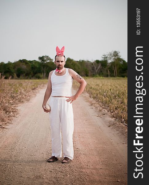 Man Wearing Bunny Hat With Big Golden Egg In The Hand. Man Wearing Bunny Hat With Big Golden Egg In The Hand