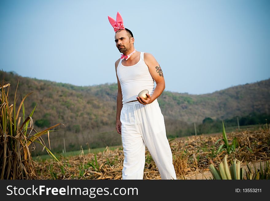 Man Wearing Bunny Hat Walking Across The Field. Man Wearing Bunny Hat Walking Across The Field