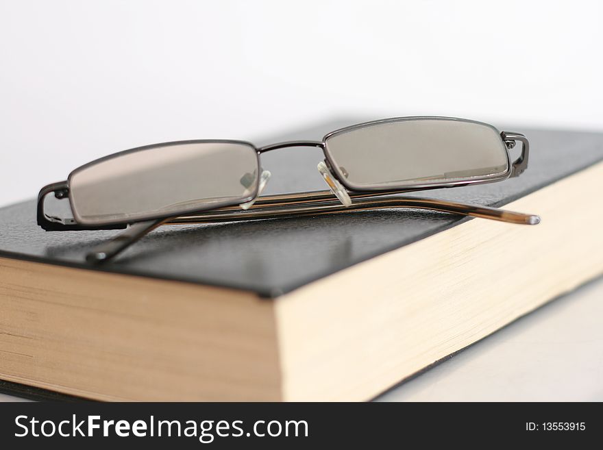 Book and Glasses isolated on white
