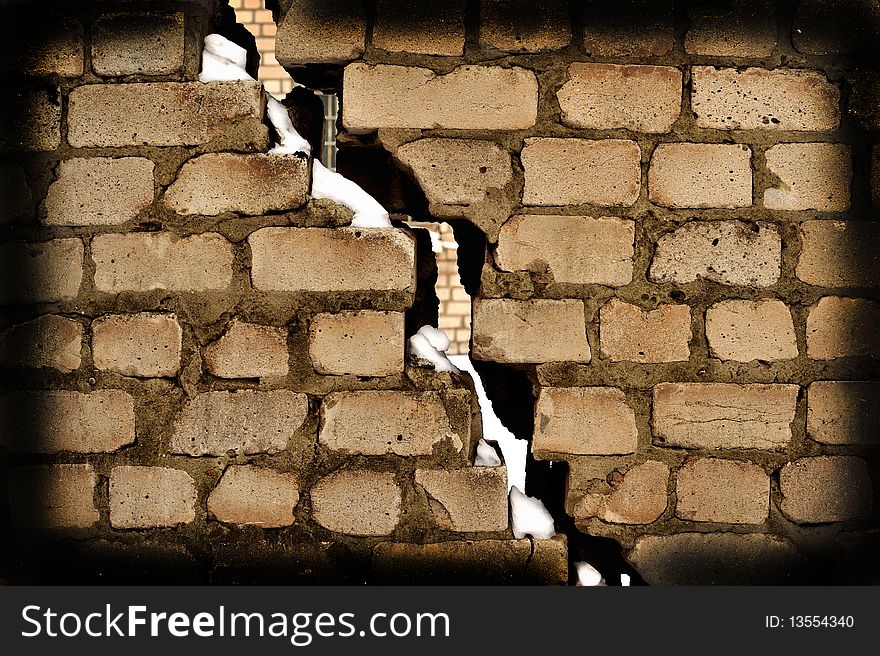 Crack in a laying from a grey old brick covered with a snow. Crack in a laying from a grey old brick covered with a snow