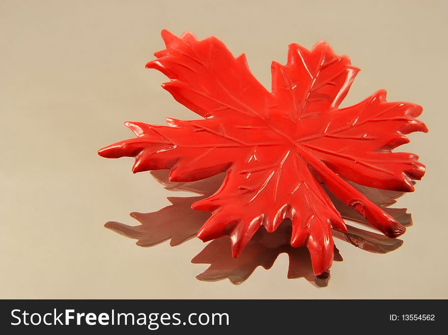Red maple artificial leaf on glass