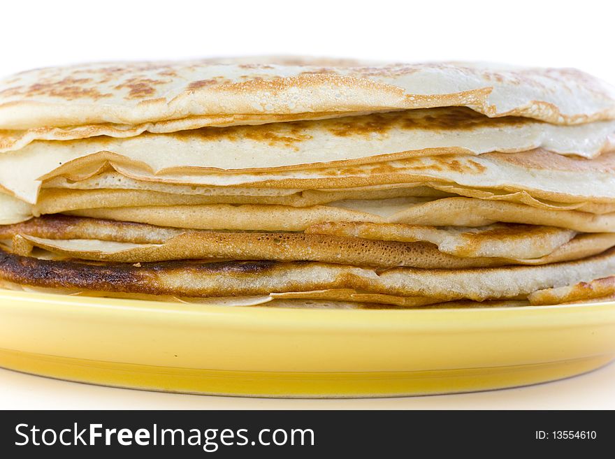 Pancakes on yellow plate on white ground