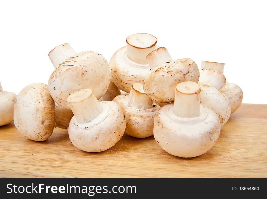 Champignon mushroom on cutting board over white