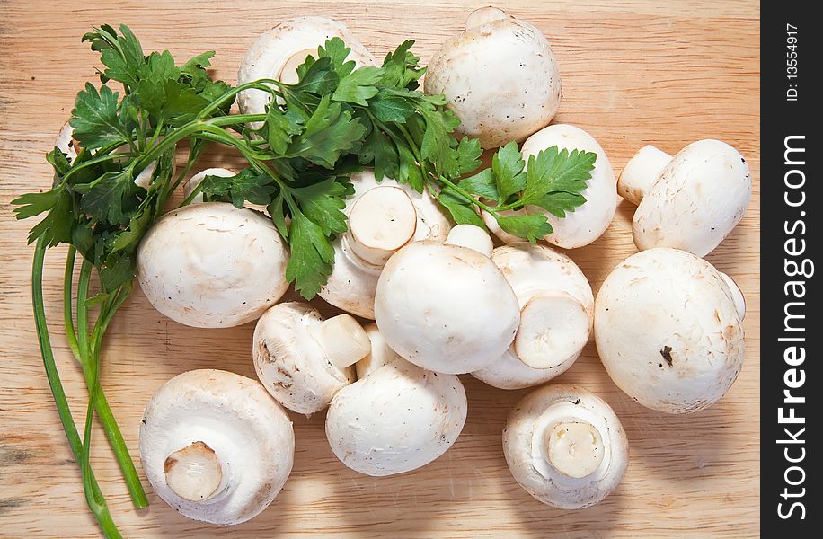 Champignon mushroom with parsley on cutting board