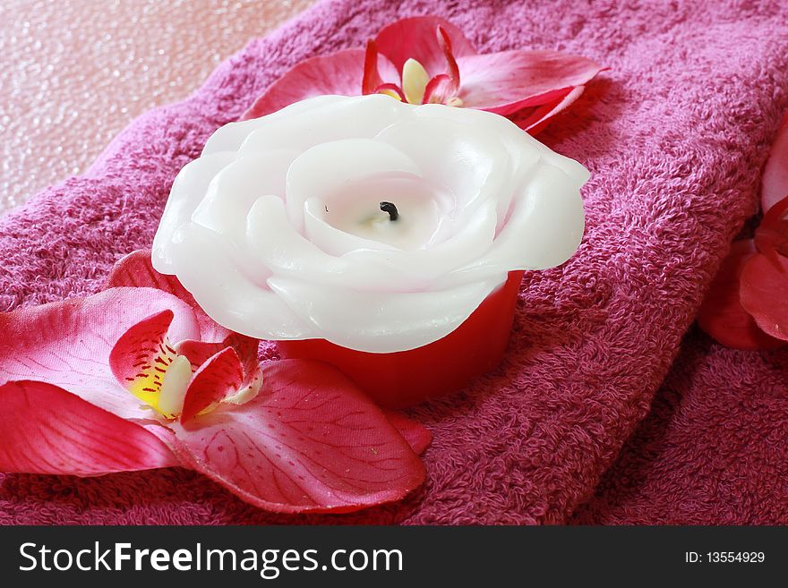A set of spa items with a decorative red flower and candles