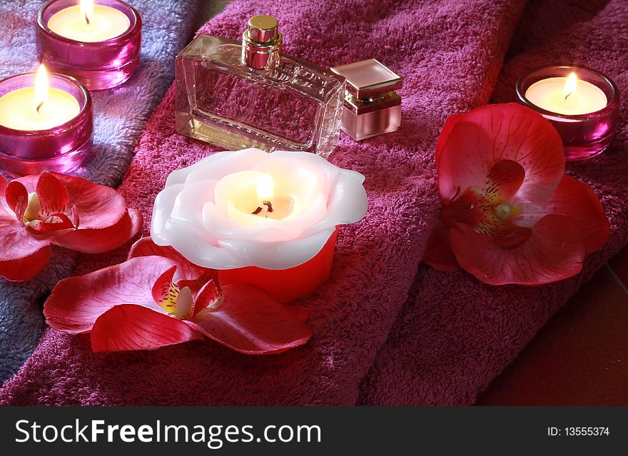 A set of spa items with a decorative red flower and candles