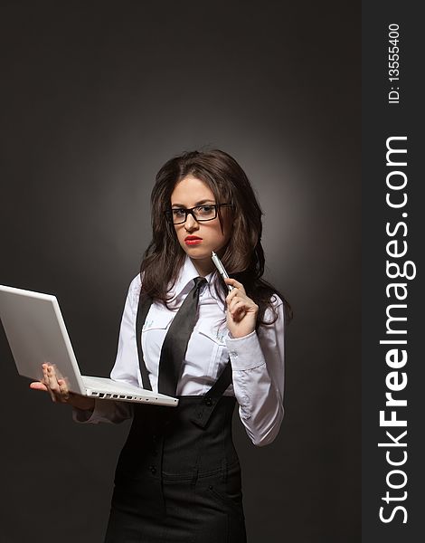 Portrait of a young attractive business woman in glasses with silver pen and white notebook at hands