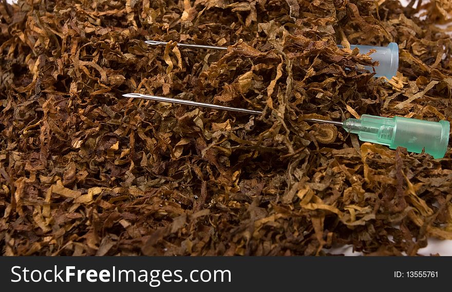 Abstract Smoking Addiction concept of pile of shredded tobacco with hypodermic needle. Abstract Smoking Addiction concept of pile of shredded tobacco with hypodermic needle.