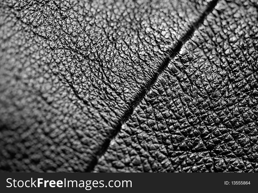 Black leather with a seam running diagonally. Macro photography. Black leather with a seam running diagonally. Macro photography.