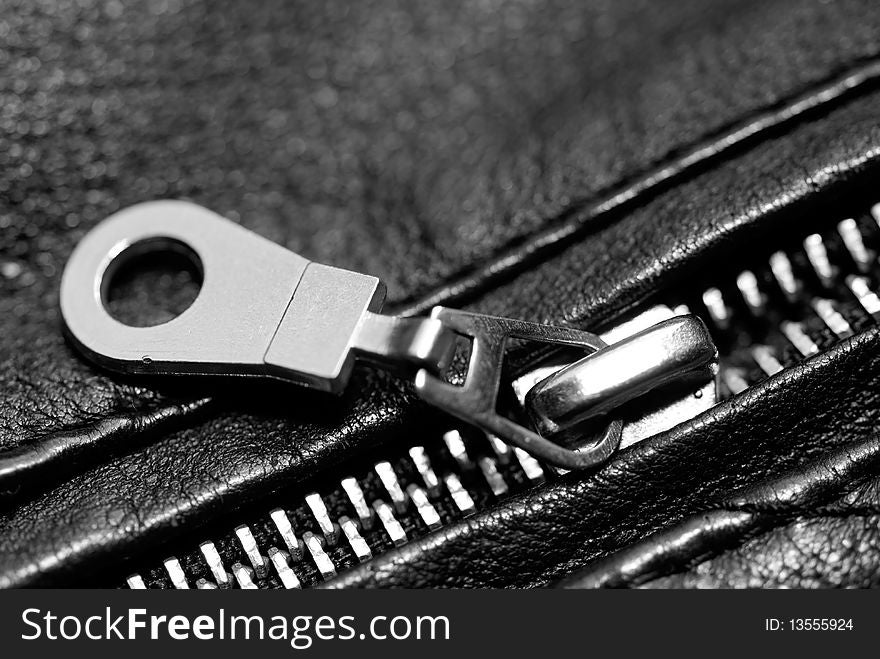 Close up of a half zipped up zipper on a black leather jacket. Close up of a half zipped up zipper on a black leather jacket.