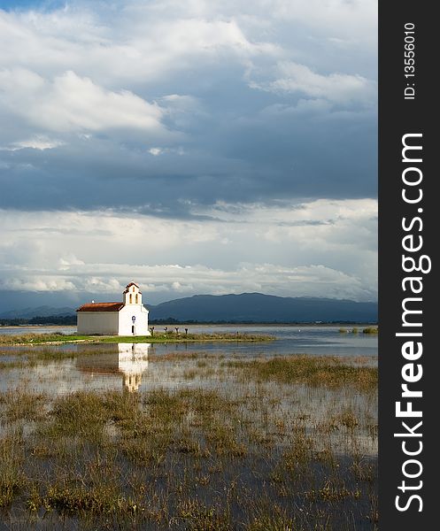 Greek church on a lake with reflection,peacefullness and a blue sky