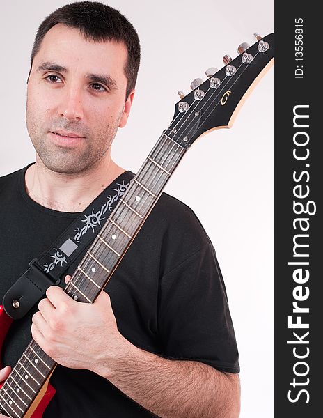 Young man with electric guitar, smiling