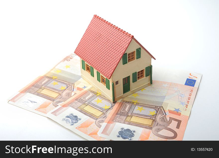Model of a house standing on some banknotes. Model of a house standing on some banknotes