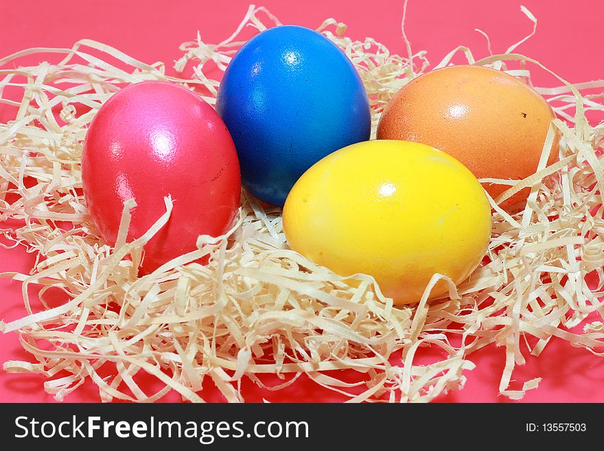 Four colored easter eggs, red, orange, blue and yellow