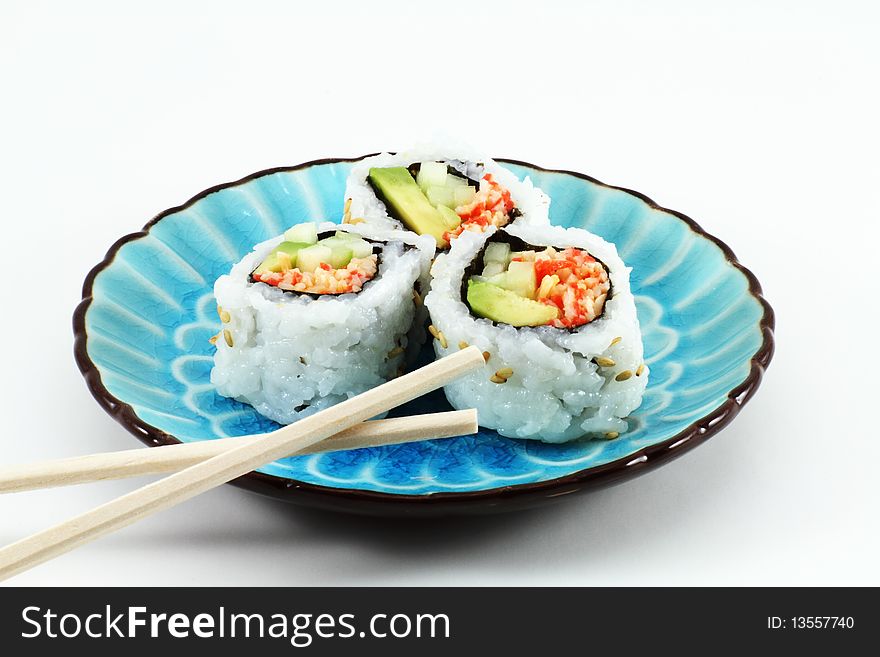 Three pieces of sushi and chopsticks on a blue dish
