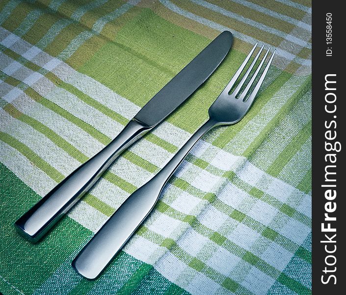 Fork and knife arranged on table-cloth