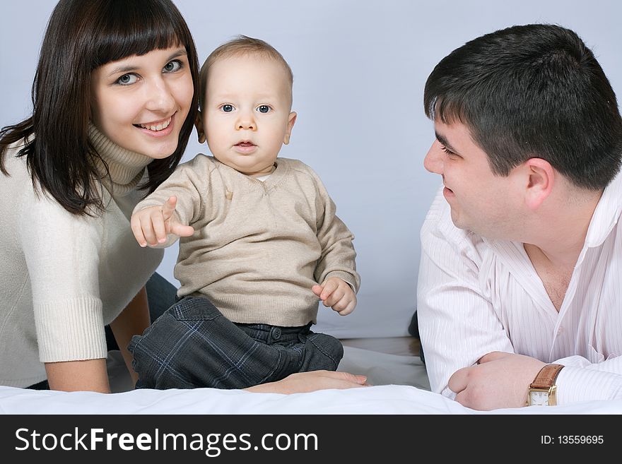 Happy family home: father, mother and baby lying on the floor and playing. Happy family home: father, mother and baby lying on the floor and playing