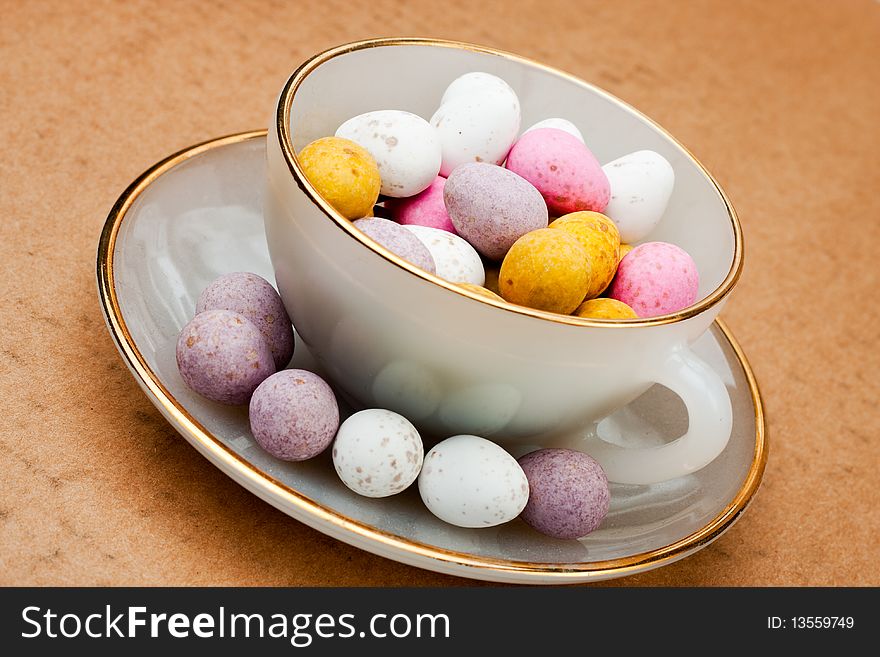 A china tea cup filled with chocolate easter eggs. A china tea cup filled with chocolate easter eggs
