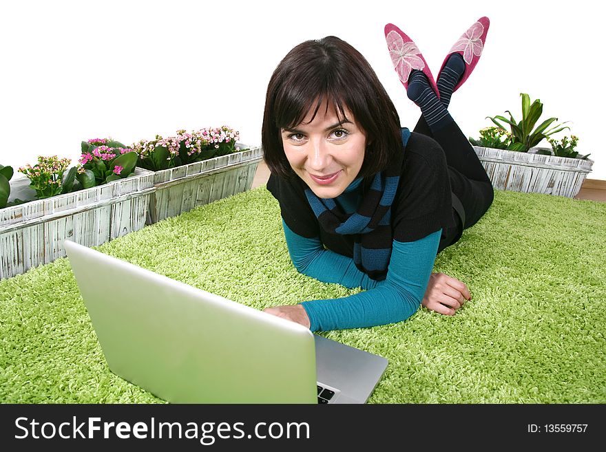 Young modern woman on laptop on green carpet at home. Young modern woman on laptop on green carpet at home