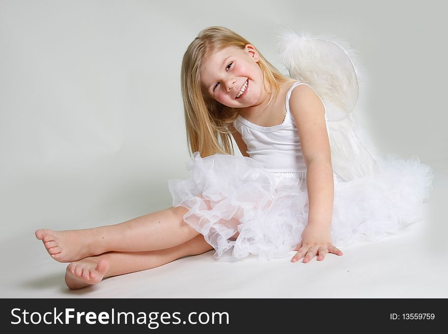 Studio shot of little smiling angel girl