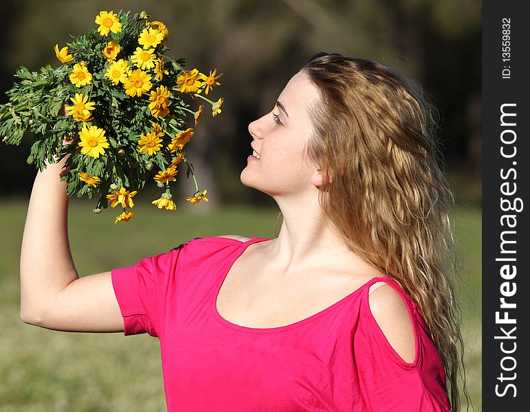 Beautiful young woman standing in blooming meadow