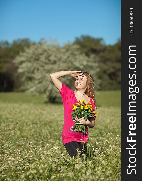 Beautiful young woman standing in blooming meadow