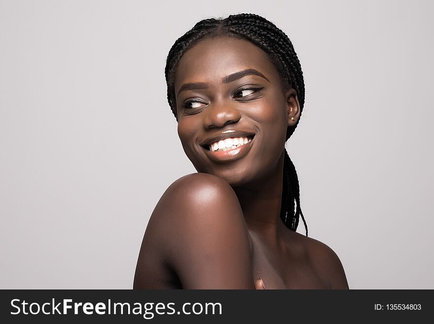 Portrait of Beautiful african woman with dark hair, fresh glowing skin face and bare shoulders isolated on white
