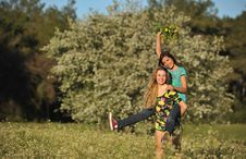 Two Beautiful Young Women Piggy-backing In Meadow Royalty Free Stock Images Two Beautiful Young Women Piggy-backing In Meadow Royalty Free Stock Images
