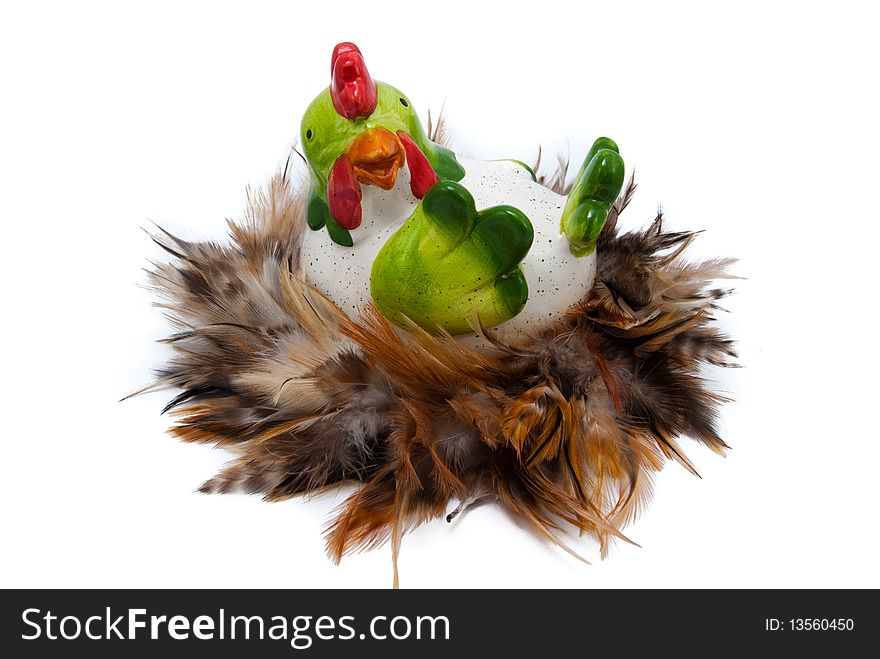 Big ceramic hen in nest which is made of feather. Easter decoration, isolated. Big ceramic hen in nest which is made of feather. Easter decoration, isolated.