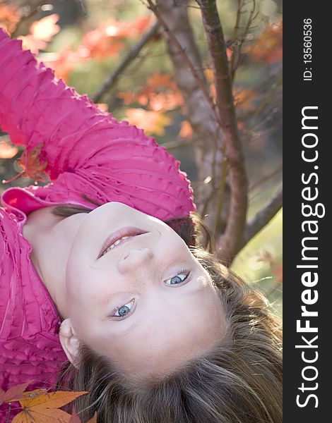 Cute young blond girl having fun hanging upside down in a tree. Cute young blond girl having fun hanging upside down in a tree