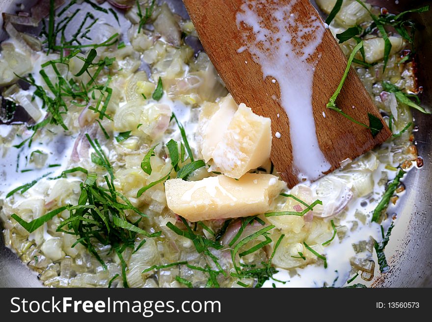 Preparing a sauce - chopped onion and cheese on a pan