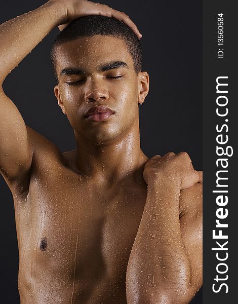 Drops of the water on naked body of a young man on black background. Drops of the water on naked body of a young man on black background.