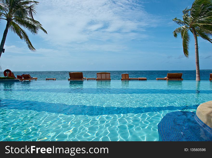 Plank bed with a chair on white sand against azure ocean. Plank bed with a chair on white sand against azure ocean