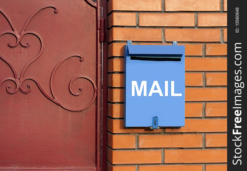 Blue mailbox on yellow brick wall