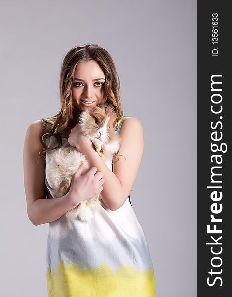 Young woman in fashionable clothing with a little rabbit