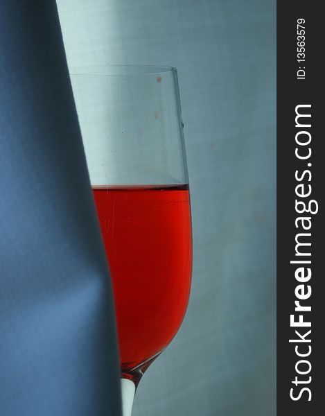 Glass with red syrup on the background and shade. Glass with red syrup on the background and shade