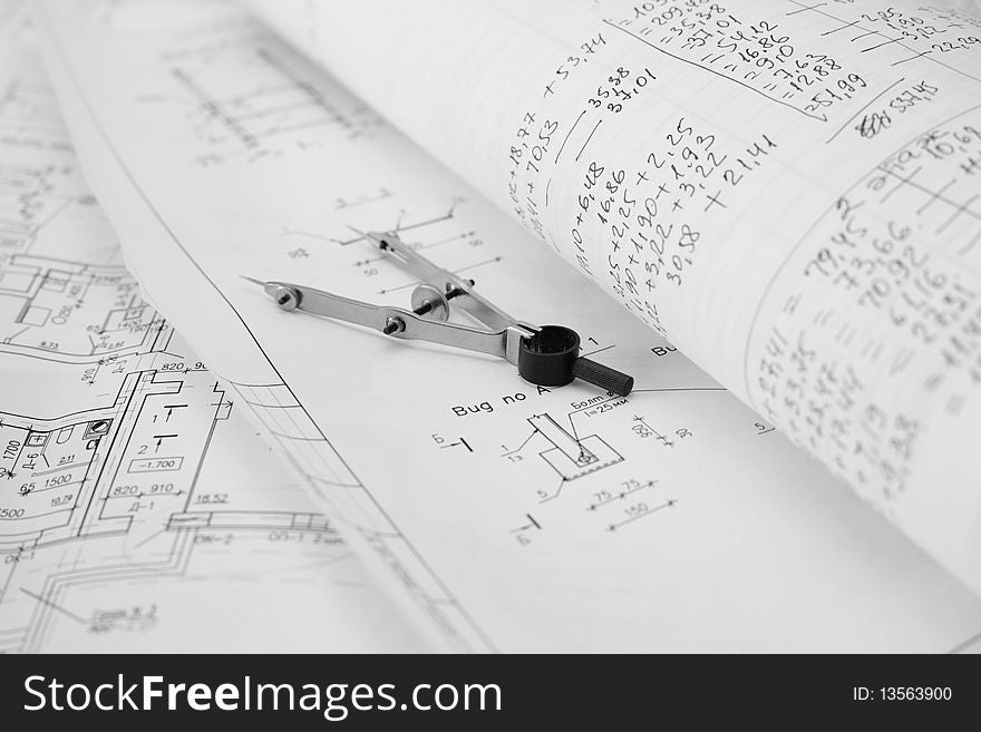 An image of metal calipers on paper