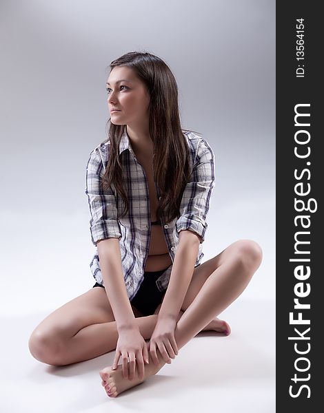 Young barefoot beautiful woman in checked shirt. Young barefoot beautiful woman in checked shirt