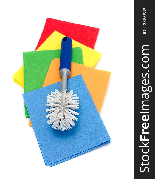 Cleaning cloths and a scrubbing brush isolated against a white background. Cleaning cloths and a scrubbing brush isolated against a white background