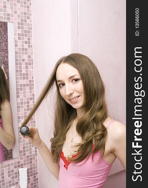 Beautiful girl combs hair a hairbrush