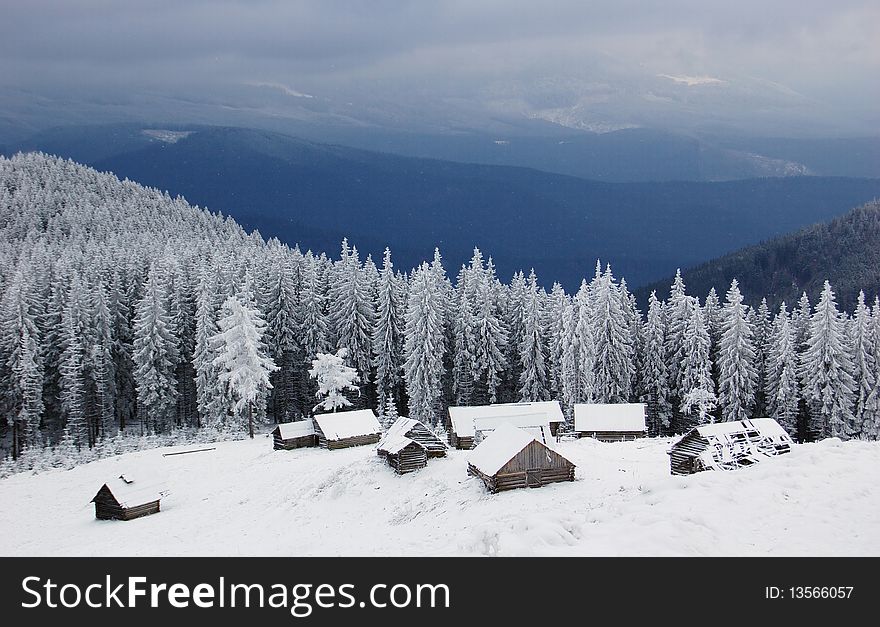 Winter landscape in mountains Carpathians, Ukraine and a valley with huts