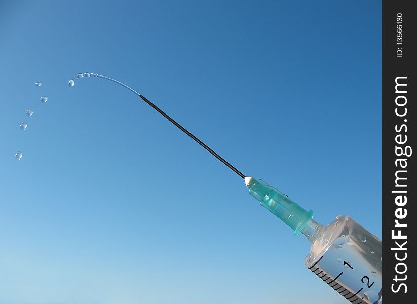Disposable syringe against the blue sky